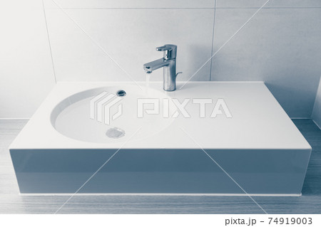 faucet with flowing water in wash sink 74919003