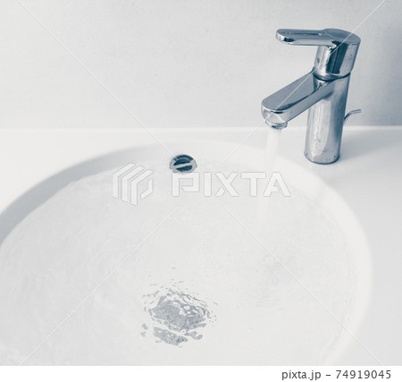 faucet with flowing water in wash sink 74919045