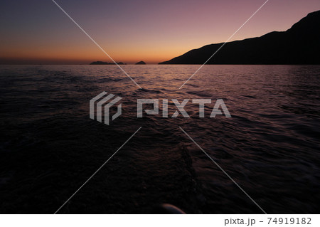 Scenic view of sea and mountains at sunset. Scenic view of sea and mountains at sunset. 74919182