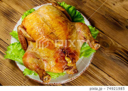 Baked whole chicken on a wooden table. Top view Baked whole chicken on a wooden table. Top view 74921985