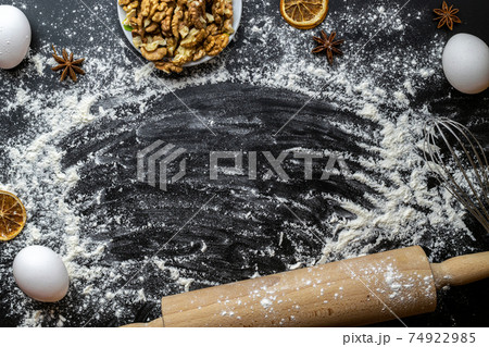 Bakery products. Cooking food ingredients: flour, eggs, nut and star anise, orange on dark table kitchen background for cake. Still life captured from above, top view, flat lay. Bakery products. Cooking food ingredients: flour, eggs, nut and star anise, orange on dark table kitchen background for cake. Still life captured from above, top view, flat lay. 74922985
