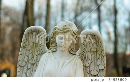 Marble white female angel with wings with blurry background Marble white female angel with wings with blurry background 74923609