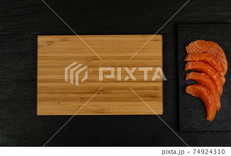 Slices of Raw Salmon Fillet on Black Background Mockup Top View Slices of Raw Salmon Fillet on Black Background Mockup Top View 74924310