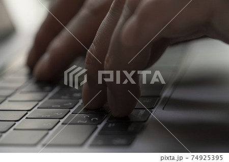 ノートパソコンでキーボード入力する男性の手 キーボードを押す指 パーソナルコンピューター ブラインドの写真素材