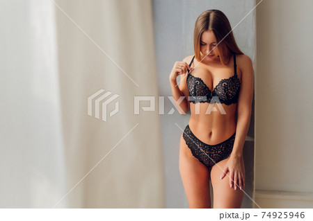 Pretty smiling girl underwear portrait near the window. 74925946