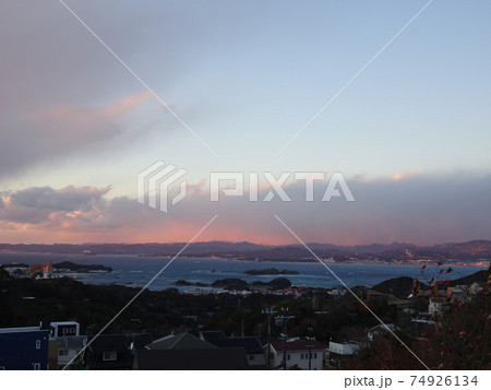 高台から見る夕暮れの海と町と山々の見える風景 74926134