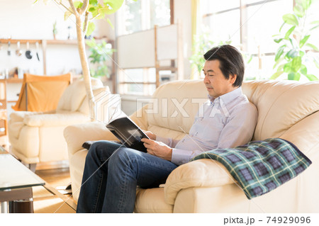 巣ごもり お家時間 雑誌を読むシニア男性の写真素材