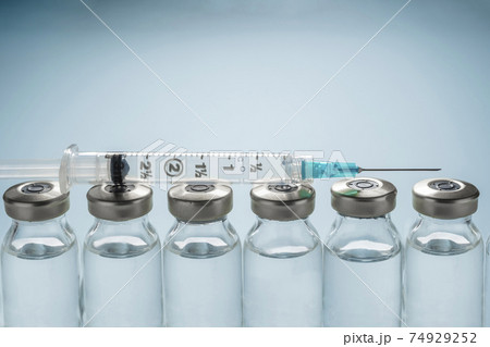 Row of Covid-19 vaccine vials and syringe Row of Covid-19 vaccine vials and syringe 74929252