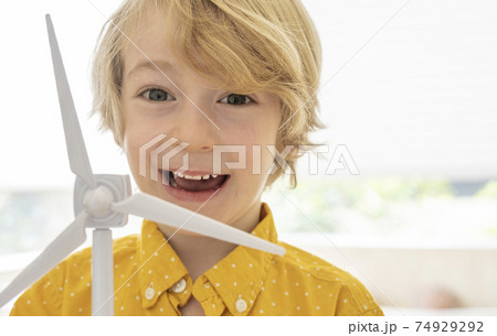 Portrait of smiling boy (6-7) with wind turbine model 74929292