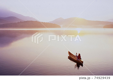 USA, New York, North Elba, Lake Placid, Woman canoeing on Lake Placid 74929439