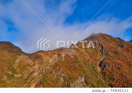 栃木県那須岳の(峰の茶屋跡避難小屋に向かう)登山道から見た紅葉の朝日岳 74930111