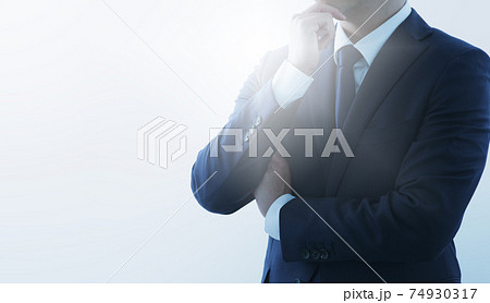 考えるビジネスマンとインスピレーション。ブルーのスーツ。逆光と余白。 74930317