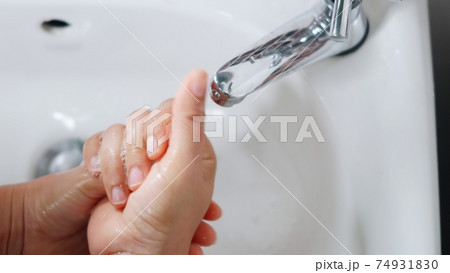 woman hands using soap and washing hands under the water tap woman hands using soap and washing hands under the water tap 74931830