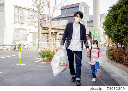 ゴミ出しをしながら女の子を集合場所に連れて行く父親 ゴミ出しをしながら女の子を集合場所に連れて行く父親 74932809