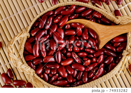 Closeup red beans or kidney bean in wooden bowl isolated on wood table background. Closeup red beans or kidney bean in wooden bowl isolated on wood table background. 74933282