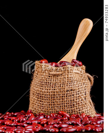 Closeup red beans or kidney bean in wooden bowl isolated on wood table background. Closeup red beans or kidney bean in wooden bowl isolated on wood table background. 74933283