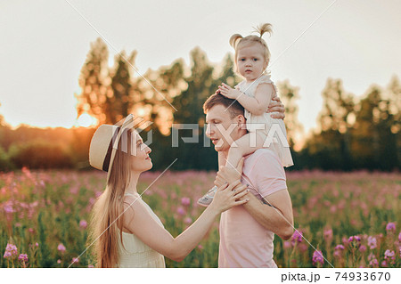 a happy family walks through a flower meadow. Love and spring blooming 74933670