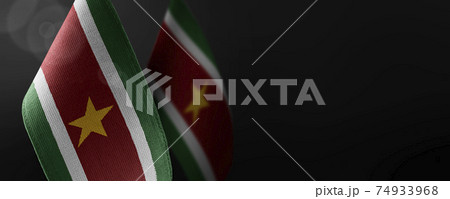 Small national flags of the Suriname on a dark background 74933968