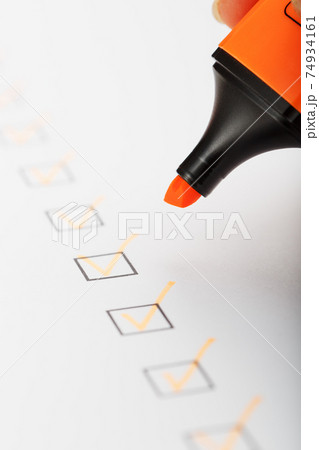 Orange marker with markers on the checklist sheet. 74934161