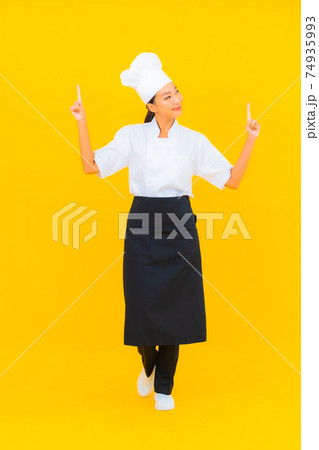Portrait beautiful young asian woman in chef or cook uniform with hat Portrait beautiful young asian woman in chef or cook uniform with hat 74935993