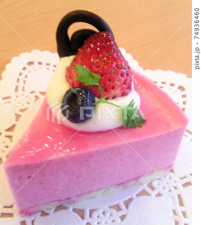 可愛いピンク色の美味しそうなラズベリームースケーキを飾るイチゴとブルーベリーとチョコと生クリームの写真素材