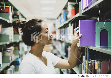 Young Asian women are searching for books and reading from the bookshelves in the college library to research and develop themselves in education Young Asian women are searching for books and reading from the bookshelves in the college library to research and develop themselves in education 74937726