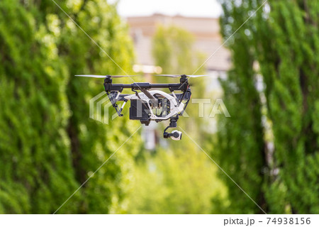 Drone flying against the background of green trees Drone flying against the background of green trees 74938156