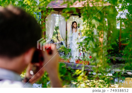 bride with bouquet of lilies kalla in a gazebo. backstage wedding photo shoot 74938652
