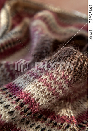 fragment of warm striped raglan sweater on pink concrete background. 74938804