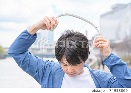 都会で、音楽コンテンツを楽しむ男性のイメージ 74938869