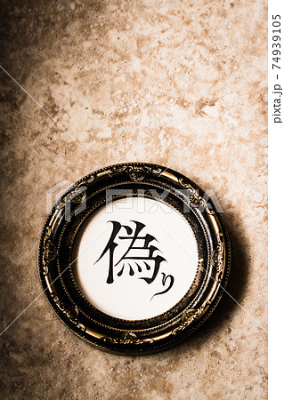 クラシカルなフレームに入った手書き文字『偽り』 74939105