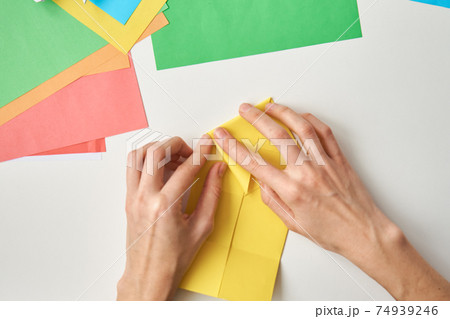 DIY concept. Woman make origami easter rabbit from color paper. Origami lessons DIY concept. Woman make origami easter rabbit from color paper. Origami lessons 74939246