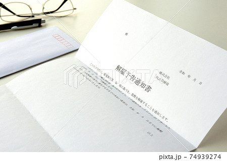 デスクに置かれた解雇予告通知書 74939274