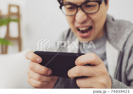 スマホでゲームをする男性 74939423
