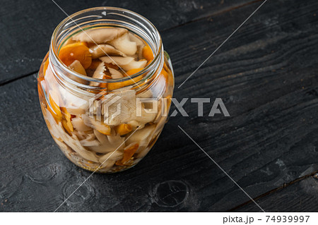 Pickled mushrooms, on black wooden table background , with space for text copyspace Pickled mushrooms, on black wooden table background , with space for text copyspace 74939997