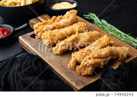 Crispy chicken tenders on black wooden background Crispy chicken tenders on black wooden background 74940245