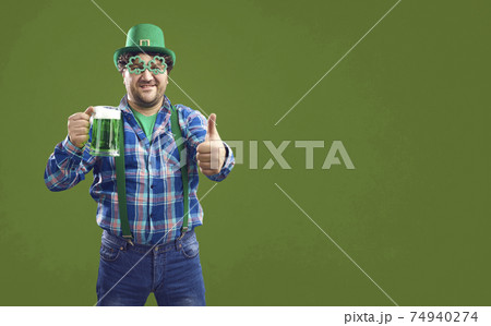 Happy Irish man holding a glass and giving a thumbs recommending good quality beer 74940274