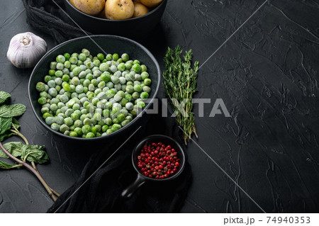 Green peas, on black textured background with copy space 74940353