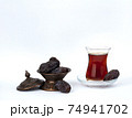 A cup of tea with dates on a plate isolated 74941702