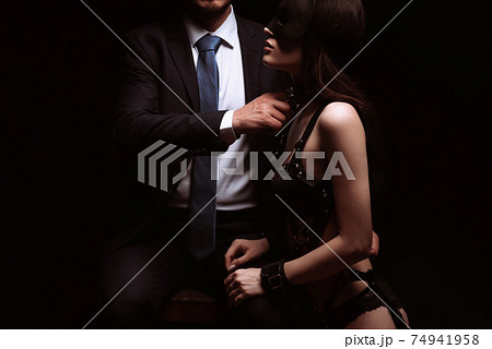 male dominant dominates submissive sexy girl in mask and handcuffs 74941958