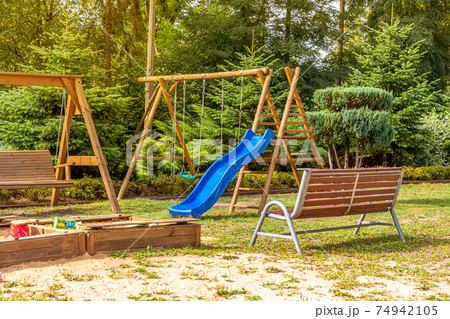 Empty modern wooden children playground set on green yard in public park in summer day. Funny toy land for kids. Urban exercise activities for child outdoors. Neighborhood childhood concept. Empty modern wooden children playground set on green yard in public park in summer day. Funny toy land for kids. Urban exercise activities for child outdoors. Neighborhood childhood concept. 74942105