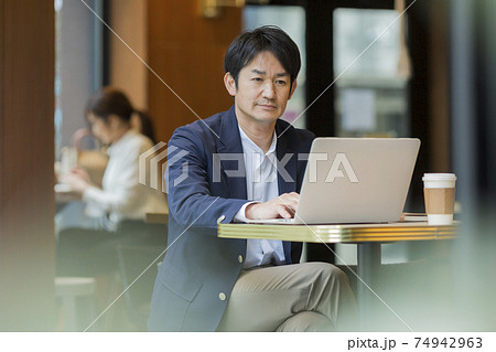 カフェで仕事をするビジネスマンの写真素材 [74942963] - PIXTA
