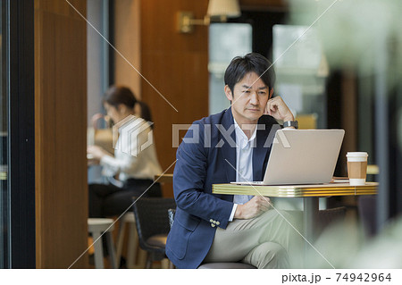 カフェで仕事をするビジネスマン 74942964