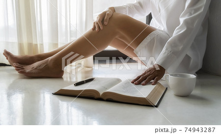 Asian woman reading a book and sitting by the window after get up in morning. Morning lifestyle concept. Asian woman reading a book and sitting by the window after get up in morning. Morning lifestyle concept. 74943287
