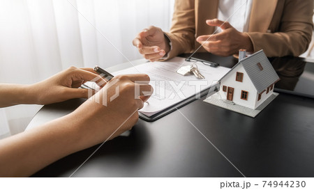 House model with agent and customer discussing for contract to buy, get insurance or loan real estate or property. 74944230
