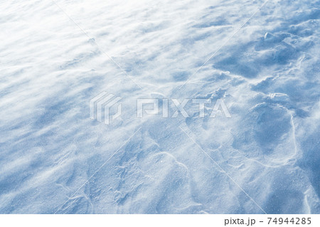 Blowing snow over snowy surface on top of mountain in Switzerland - snowstorm Blowing snow over snowy surface on top of mountain in Switzerland - snowstorm 74944285