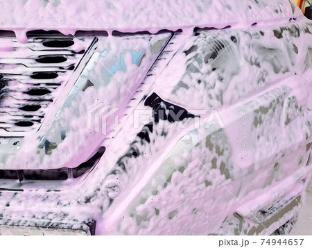 dirty car radiator grille and headlight covered with foam for washing and cleaning from dirt and insects, nobody closeup details. dirty car radiator grille and headlight covered with foam for washing and cleaning from dirt and insects, nobody closeup details. 74944657