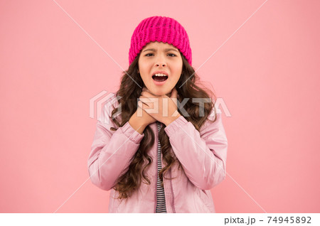 she has sore throat. cold climate weather. happy little girl 74945892