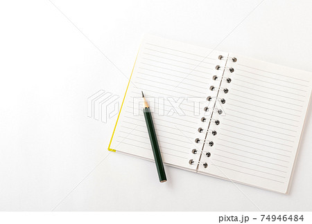 線の入った白いメモ帳と 短い先の尖った鉛筆の写真素材