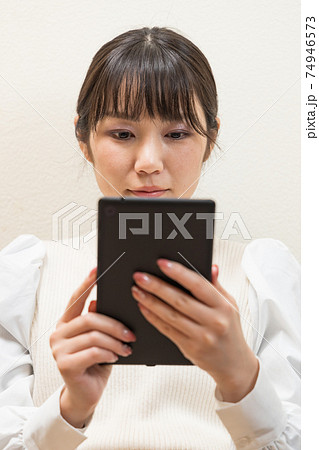 ソファに座ってタブレットを持つ女性 74946573